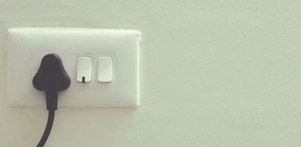 White wall switch plate with a plug connected to a socket