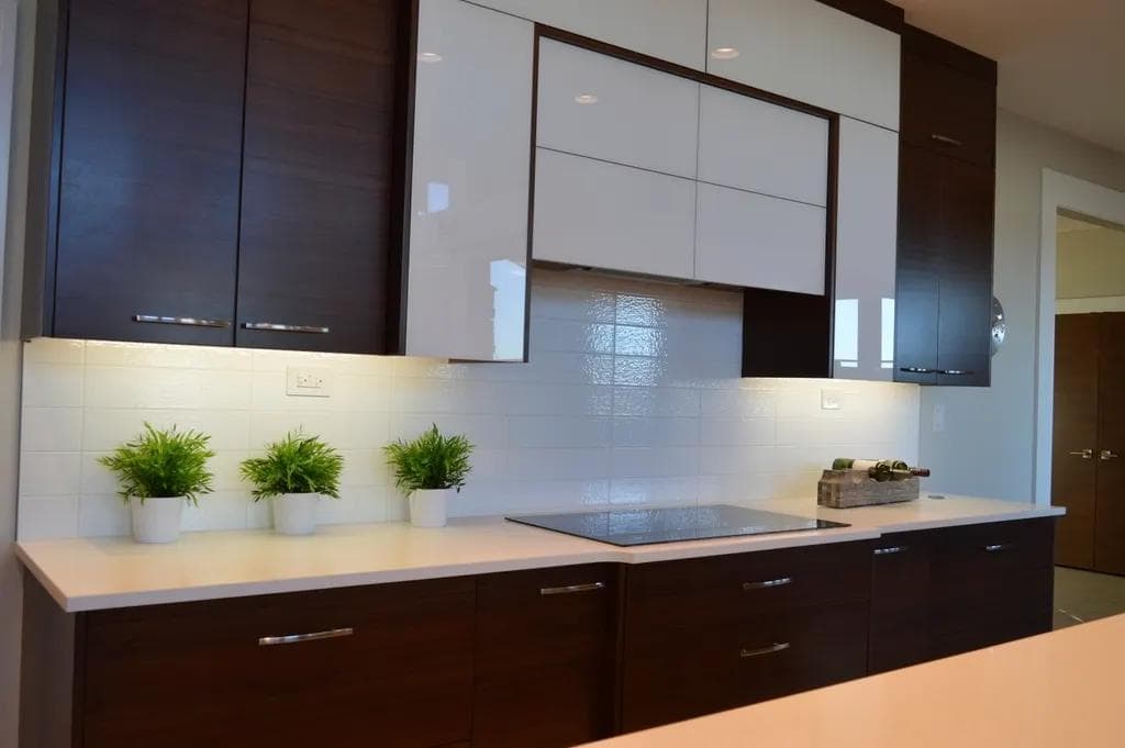 Modular kitchen with dark lower cabinets, white wall cabinets and a hob